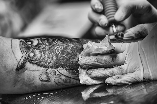 owl tattoo symbol being applied to a man's arm