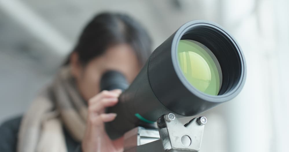 woman looking through scope for birding
