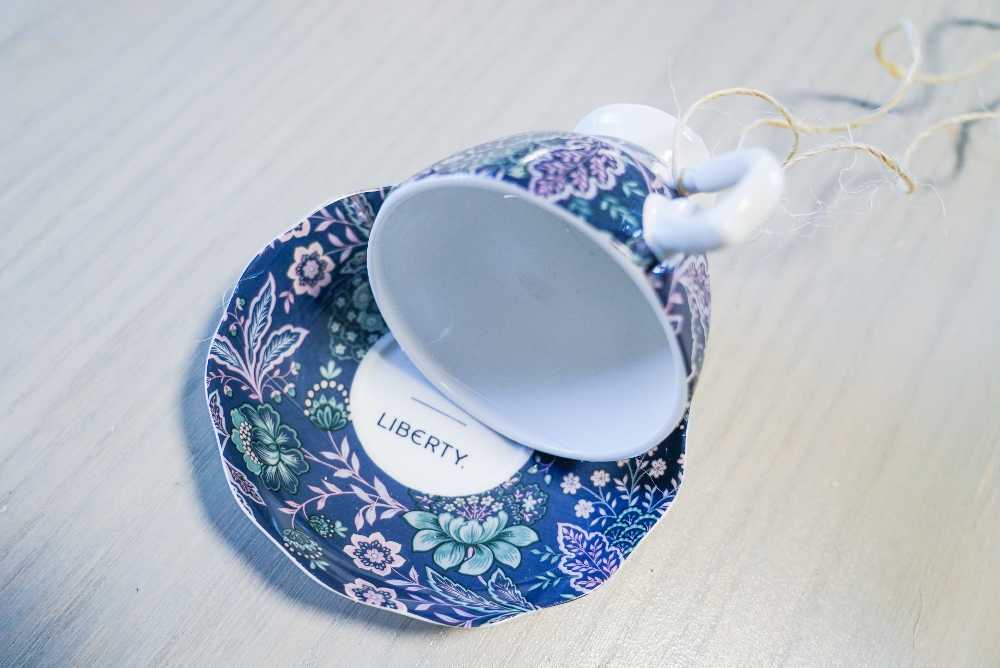 teacup bird feeder on a saucer